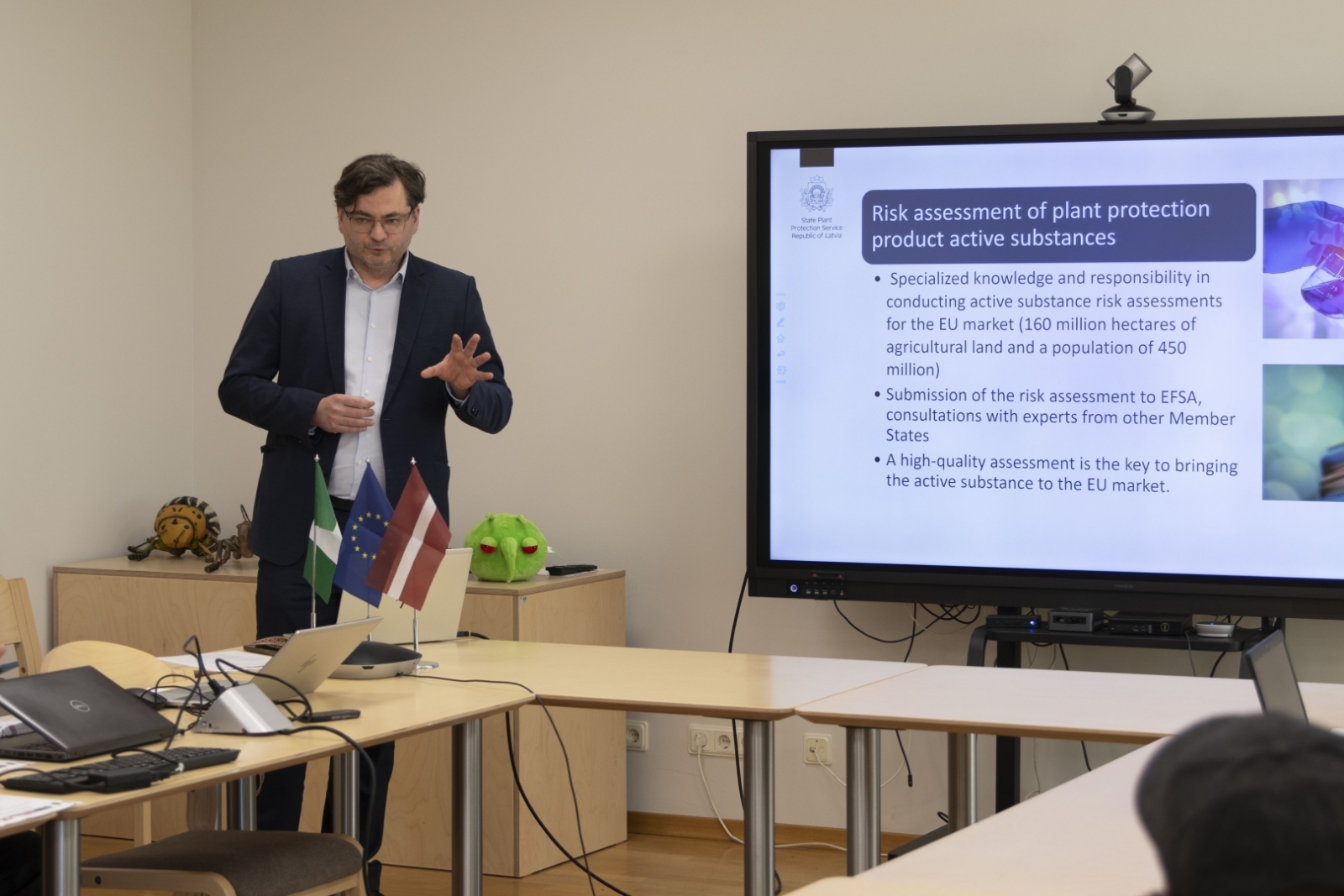 Direktora vietnieks prezentē konferenču zāles priekšā