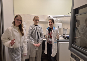 trīs meitenes stāv  laboratorijā