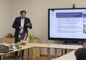 Direktora vietnieks prezentē konferenču zāles priekšā