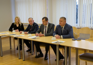 Ukrainas delegācija 4 cilvēki sēž sanāksmes zālē pie galda 