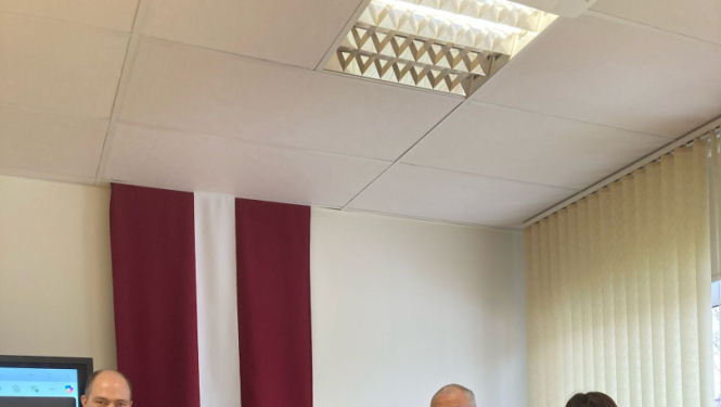 Attēls ar 5 cilvēkiem un Latvijas, sarkanbaltsarkano krogu fonā.