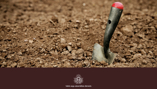 Augsnē iesprausta neliela dārza lāpstiņa