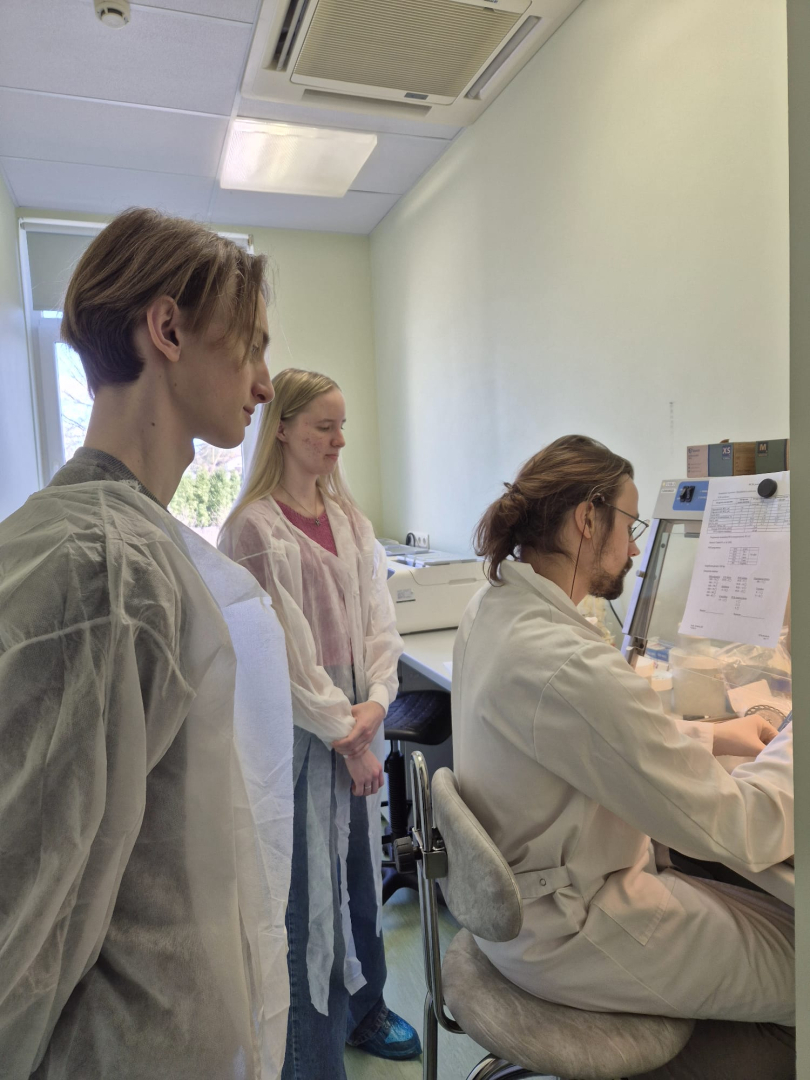 trīs jauni cilvēki iepazīst laboratorijas darbu