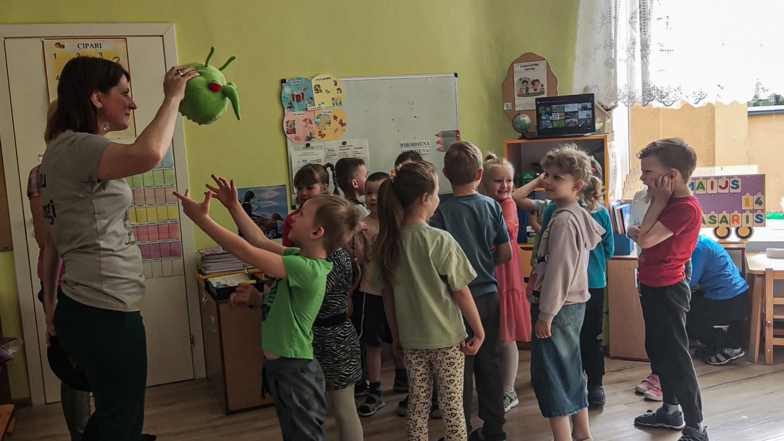 Jālija  rāda pestiju, bērni sastājušies un skatās, paceltas rokas, kāds grib patausīt mantu