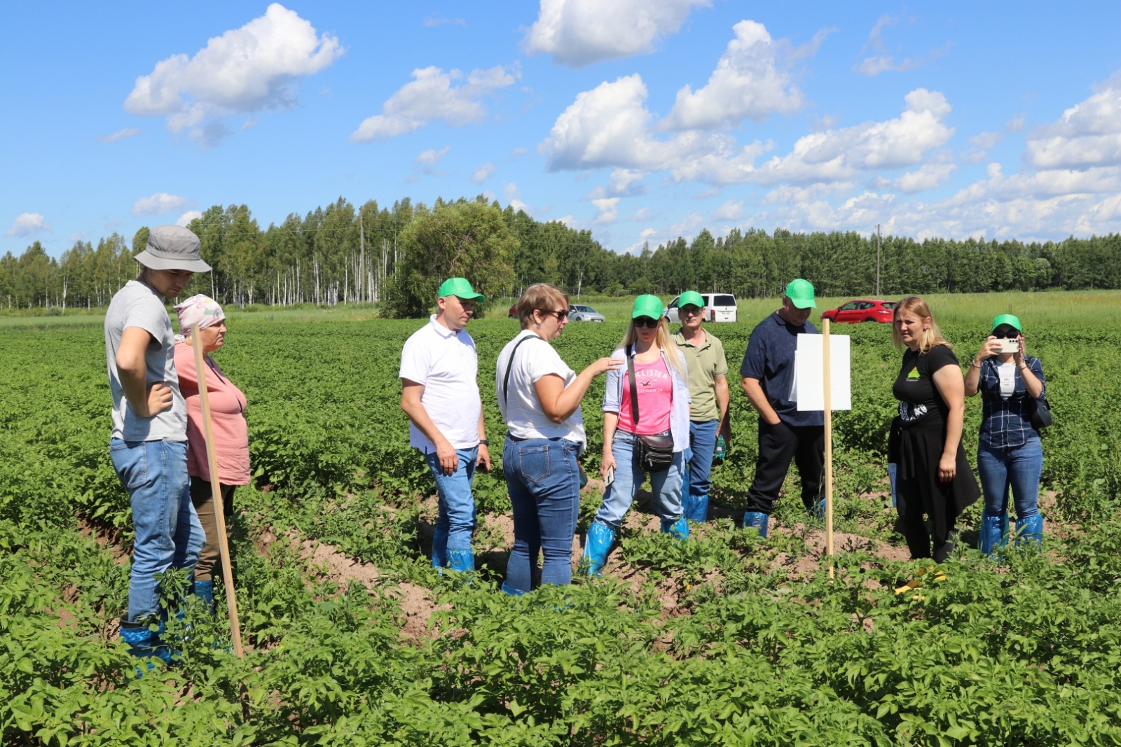 Kartupeļu laukā cilvēki klausās agronoma stāstīto